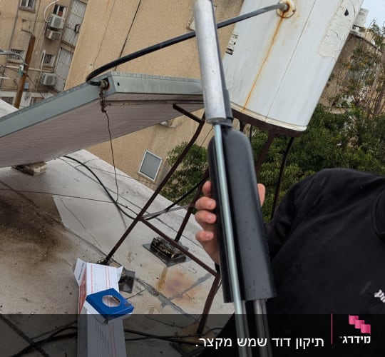 דוד שמש על גג עם צינור וחלקי מתכת